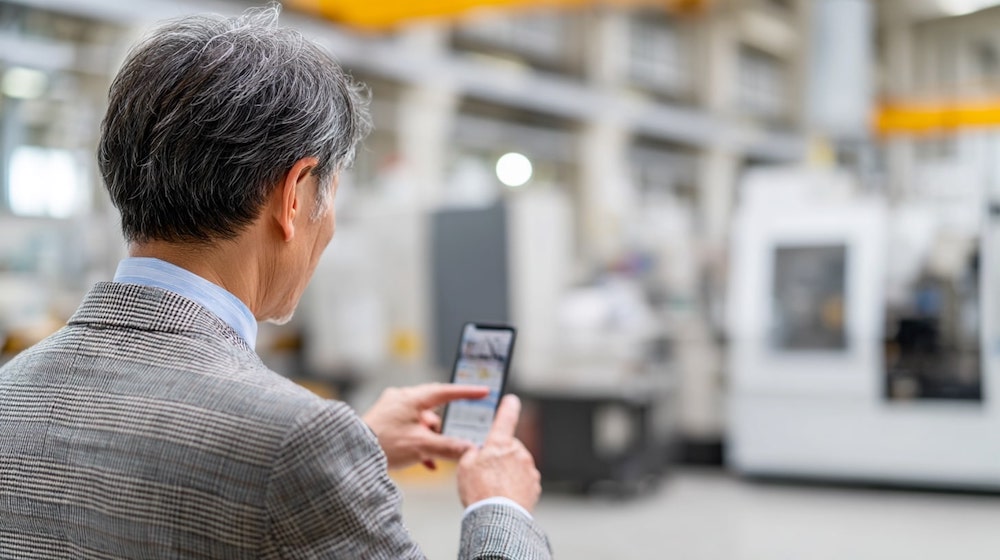 実際の申込み画面を説明する山田社長(仮名)。スマートフォンからも簡単に申込み可能